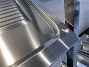 Stainless steel commercial kitchen sink with sleek, polished finish and integrated drainboard
