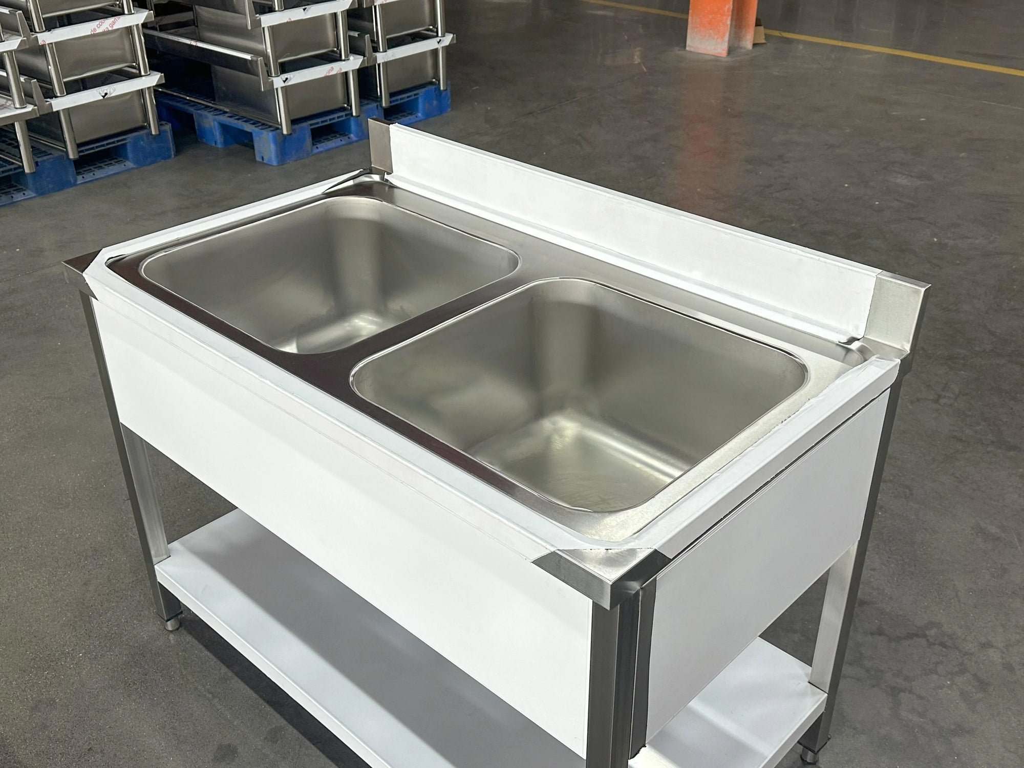 Stainless steel double sink worktable for commercial kitchens with storage shelf