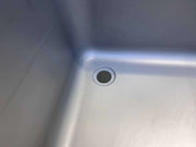 Stainless steel commercial sink with circular drain, ideal for industrial kitchens